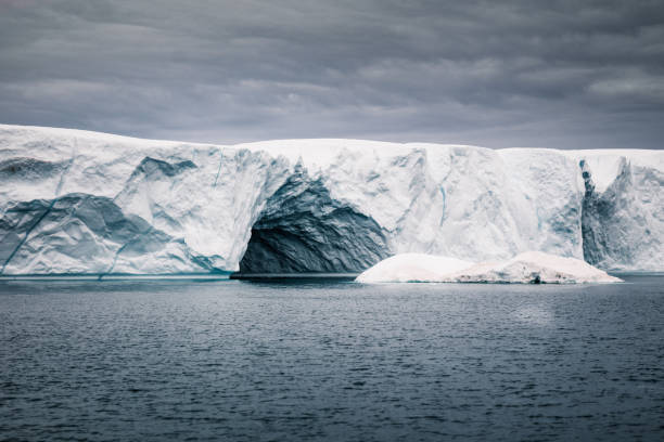 Ice Cave in Greenland Iceberg Under Dramatic Skyscape