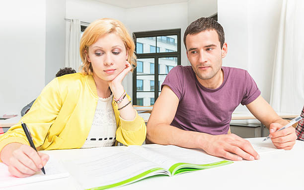 Young man cheating test in classroom copying exam